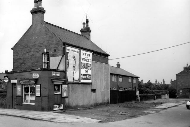 Hall Lane and Strawberry Road in May 1965. On the left of this view is a small one-storey shop, Woodwards greengrocers at number 87 Hall Lane. This shop backs onto the side of number 1 Haywood Yard. Billboards are attached to the back of this property. Strawberry Road runs to the right edge.