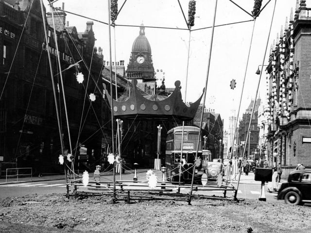 Coronation decorations on East Parade, looking towards The Headrow and Calverley Street. Leeds Town Hall is in the background. A bus on the number 42 route is going to lower Wortley. On the right is the junction with Russell Street. The roundabout in the middle no longer exists.