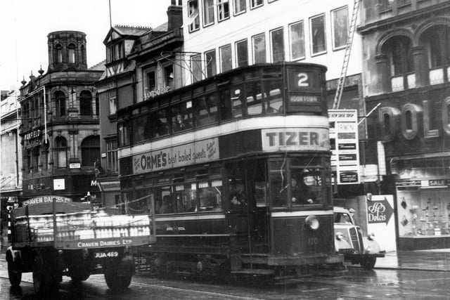 Tram no 120 travelling along Briggate on Route 2 to Moortown in July 1956. Dolcis Footwear can be seen on right with Manfield and Son Bootmakers visible on junction with Commercial Street. A Craven Dairies delivery van can also be seen.