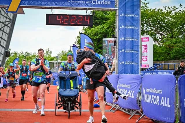 Kevin Sinfield carries his former teammate over the finish line at the end of the Rob Burrow Leeds Marathon. Picture by Jane Tomlinson’s Run For All.