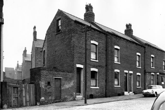 Pontefract Lane in September 1966. Pictured is a row of houses with the gated entrance to a yard on the left. On the right of this is the shared outside toilet before the advent of indoor plumbing.