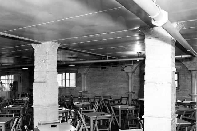 The canteen at Marshalls Mills. Member of canteen staff and two mill workers on left. The supporting brick pillars in Egyptian temple style are in view. Pictured in August 1956.