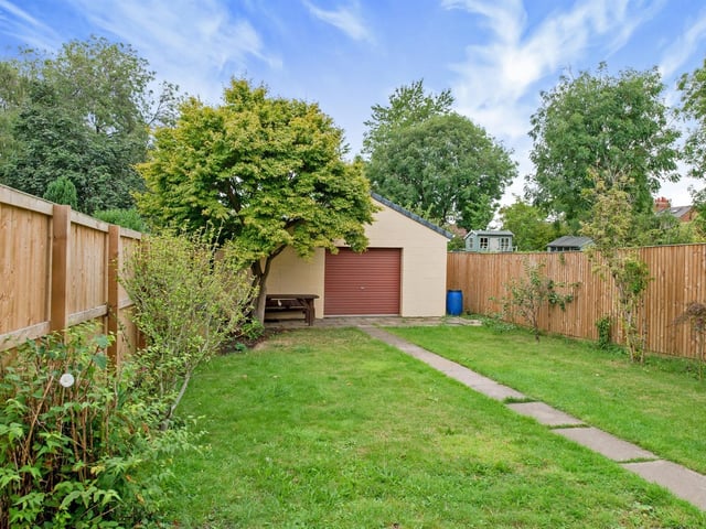 A larger than average garage store is situated at the top of the garden.