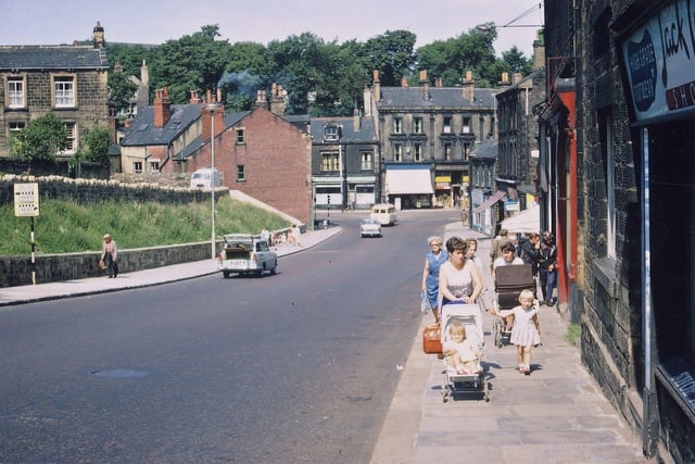 Looking down the final part of Scatcherd Hill into Morley Bottoms. The view is taken outside Jack Wilcock's shop and the buildings on the right hand side are as they have been for many years but on the left hand side there has been widespread clearance of shops, the road has been widened, the pavement widened and a banking made for shrubs and bulbs. Pictured in August 1967.