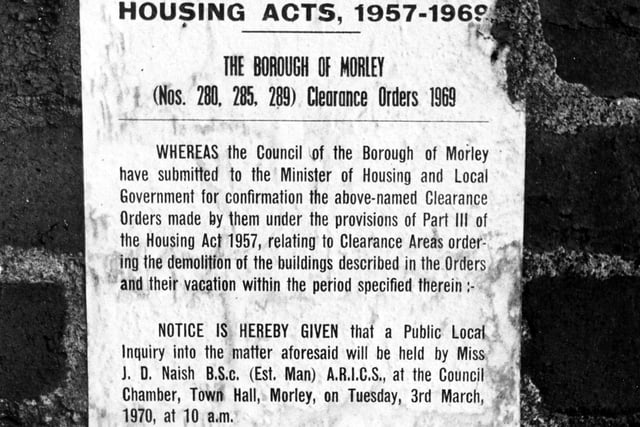 A notice on the wall of a house on Parker Street in Morley. The notice is headed 'Housing Acts, 1957-1969' and relates to the Clearance Orders' of 1969. It advertises a public inquiry into the demolition of the buildings to be held at the Council Chamber, Town Hall, Morley, tuesday 3rd March, 1970 at 10am.