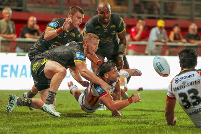 Leeds Rhinos' Lachie Miller, Ash Handley and Maika Sivo tackle Nick Cotric of Catalans Dragons. Picture by Rémi Vignaud/Catalans Dragons/SWpix.com.