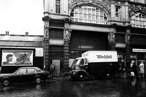 Looking from Ludgate Hill to the side entrance to Kirkgate Market, which is blocked from view by a lorry with the name 'Weddel' on the side. Willis Ludlow department store, is on the right and on the upper floor above the entrance. Pictured in January 1979.
