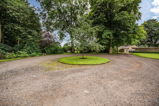 A long, gated driveway gives entry to the grounds with its three acres of gardens.
