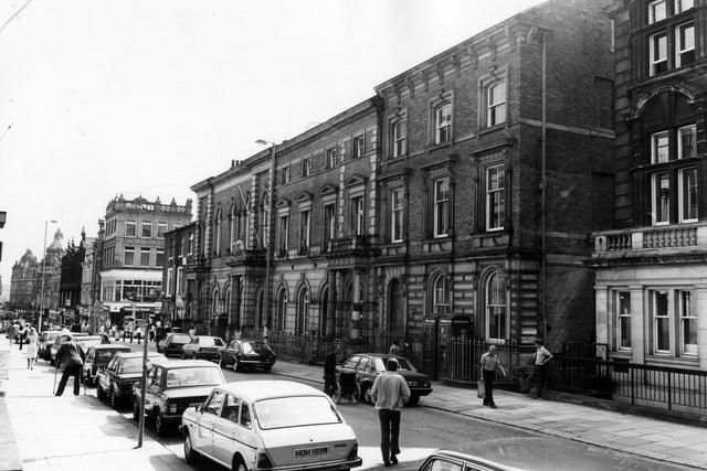 Albion Place with the County Court building prominent, dating from circa 1870. Many parked cars and pedestrians can be seen. In the background, Pickfords Travel is visible on the ground floor of the Longley building on the corner with Lands Lane. Pictured in August 1983.