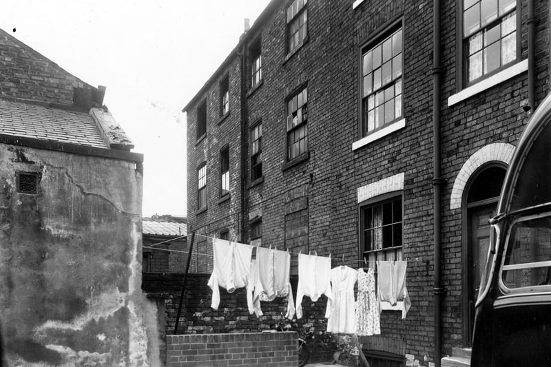 Back-to-back properties in a yard off Belgrave Street in September 1959. On the left are the derelict properties of numbers 48 and 50. On the right is number 56 where clothes hang on a line stretched across the yard outside.