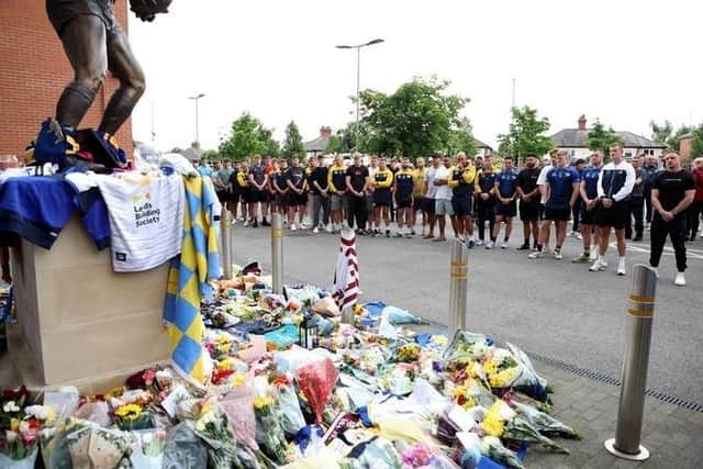 Leeds Rhinos players pay their respects to Rob Burrow as they admire tributes left alongside the John Holmes statue at AMT Headingley. Picture by Ed Sykes/Getty Images.