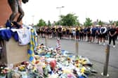 Leeds Rhinos players pay their respects to Rob Burrow as they admire tributes left alongside the John Holmes statue at AMT Headingley. Picture by Ed Sykes/Getty Images.