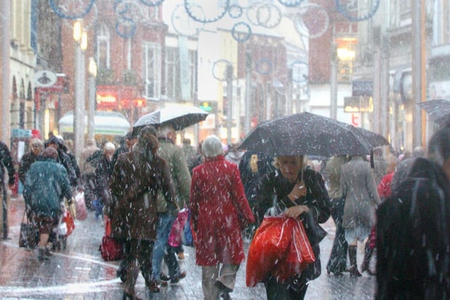 Shoppers walk through falling snow in Leeds City Centre to get the bargains in the Christmas Sales in 2005.