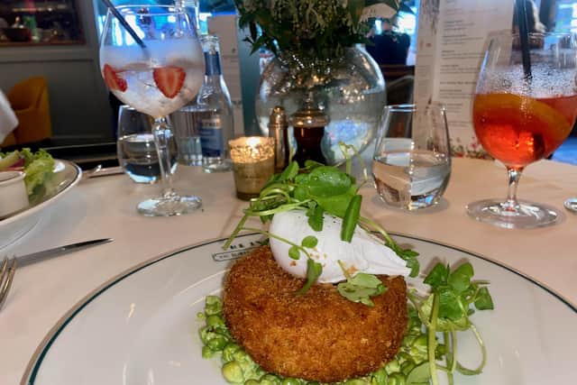 The Scottish smoked haddock and salmon fishcake - served on a bed of crushed garden peas in a fresh herb sauce and topped with a poached hen’s egg
