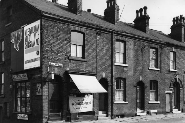 Located at the corner of Disraeli Terrace on the left and Lady Pit Lane on the right is number 41 has newsagent and tobacconist Dave Cochrane (a former Leeds United football player), advertised for sale are Capstan medium cigarettes, June magazine, players cigarettes and Wills Woodbines.