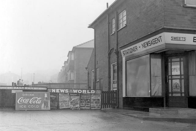 Newsagent and sweet shop, business of Edward Hutchinson pictured in January 1940. It was located  at the corner of Heath Grove, opposite Leeds United football ground on Elland Road. Placards for various newspapers can be seen, including Sunday Express, Sunday Dispatch and Reynolds News. Advertisement for Coca-Cola.