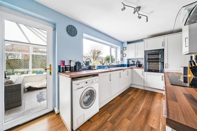The modern style fitted kitchen has gorgeous wooden worktops and an entrance into the conservatory.