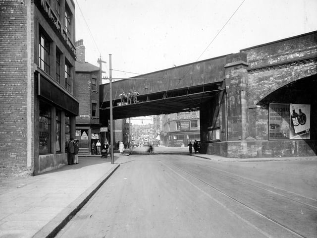 Looking towards Kirkgate from beyond the railway bridge in August 1935. Junction of Wharf Street and Cross York Street can be seen. L.Vaux wholesalers stands on corner with Wharf Street. Three workmen pose on railway bridge. I.J.Pewhurst wholesale drapers wharehouse stands on corner just beyond railway bridge.
