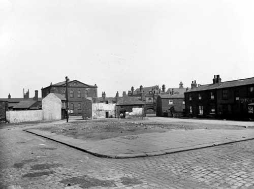 A view from Albion Terrace across waste ground, to Waterloo Road. Garden Gate pub just visible. Pictured in  May 1936.