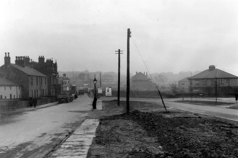 A view from Station Road in February 1938, looking in the direction of Whitkirk across the railway bridge before it was widened On the left is the Station Hotel, a Tetley public house, and beyond the Ritz Cinema can be just be seen in the distance. Vehicles in view, including a bus crossing the bridge. On the right is the junction with Coldwell Road.