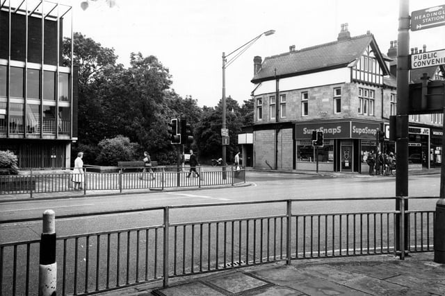 Otley Road showing the junction with Wood Lane in the centre in March 1980. On the left is the edge of the Arndale Centre; on the right SupaSnaps Film Processing, Bradleys Video and TV Centre and Woodcock Travel can be seen.