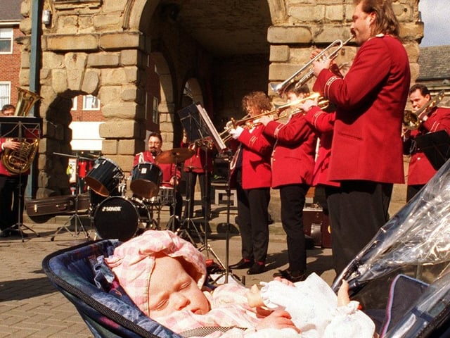 Young Katie Walton dozes as a band from Germany, Orchestra Herne 62, entertains shoppers in Pontefract town centre in April 1996.