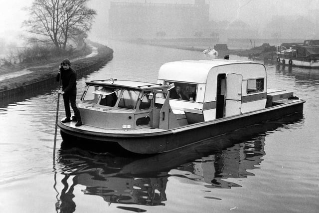 A caravan sets sail in a specially designed boat on the Leeds Liverpool Canal in January 1971. The craft designed to carry a caravan on inland waterways is the brainchild of 
John Kippax. The 30-year-old, a director of Bradford Boats Services Ltd., had-toyed with the idea of building the craft for several years after caravan owners had booked one of the firm's cruisers for a holiday on the Leeds-Liverpool canal. "They had to leave their caravans at home and I thought it would be a good idea to build a boat with the engine after and the control cabin forward and a deep well in the middle," he said.