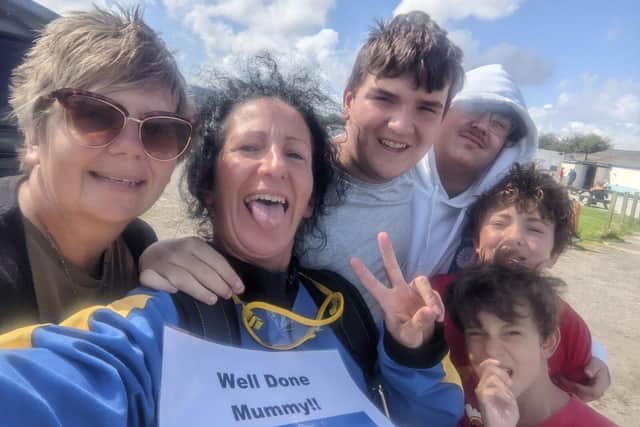 She was cheered on by her four sons as she made the 14,000ft jump to raise money for cancer research