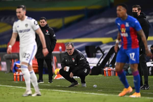 Leeds United head coach Marcelo Bielsa reacts from the touchline holding his cup whilst crouching during the Premier League match between Leeds United and Crystal Palace at Elland Road on February 8, 2021.