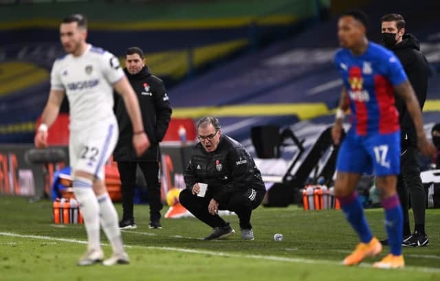 Leeds United head coach Marcelo Bielsa reacts from the touchline holding his cup whilst crouching during the Premier League match between Leeds United and Crystal Palace at Elland Road on February 8, 2021.
