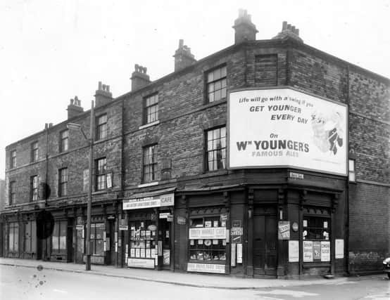 A view of old shop premises in Hunslet Lane at the junction with South Row. In view is a greengrocers, proprietor, Harry Sidebottom, a tobacconists shop and Jim's Cozy Cafe. A sign above the window advertising the News of the World newspaper states 'Mr Anthony Armstrong-Jones, the unknown celebrity' South Market Cafe is on the corner at number 58. The row was demolished in accordance with he 1957 Housing Act.