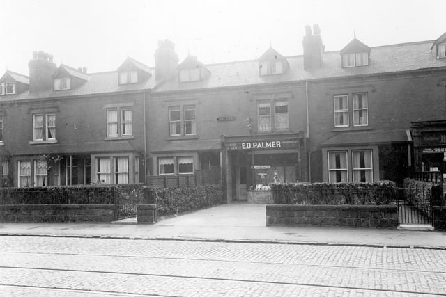 A row of terrace houses in August 1935. Number 587, premises of Edward David Palmer, ladies and gents hairdresser, the front garden wall has been removed. The shop on the right number 591 is that of Philip Humphreys, grocer.