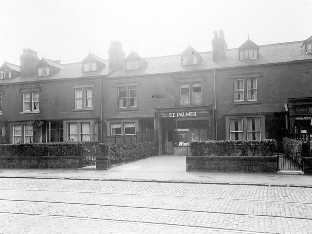 A row of terrace houses in August 1935. Number 587, premises of Edward David Palmer, ladies and gents hairdresser, the front garden wall has been removed. The shop on the right number 591 is that of Philip Humphreys, grocer.