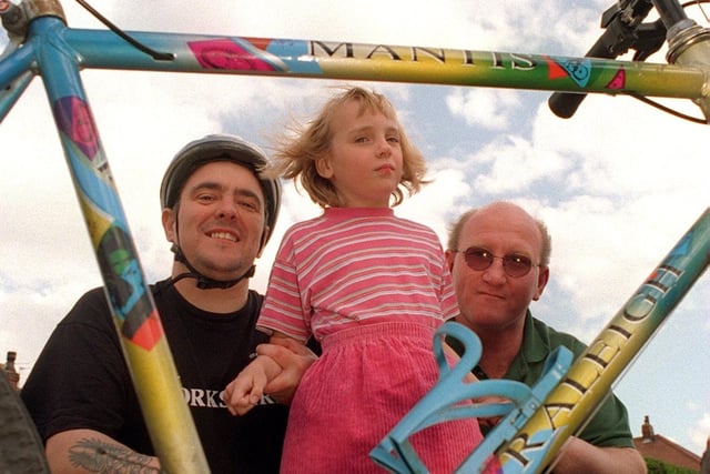 Young autism sufferer Claire Copley from Allerton Bywater pictured in May 1997. Her dad's friend, Kevin Weaver, was preparing to do  a solo triathlon to raise money to send Claire away for specialised treatment. Pictured is Claire and dad Tommy with Kevin and his bike.
