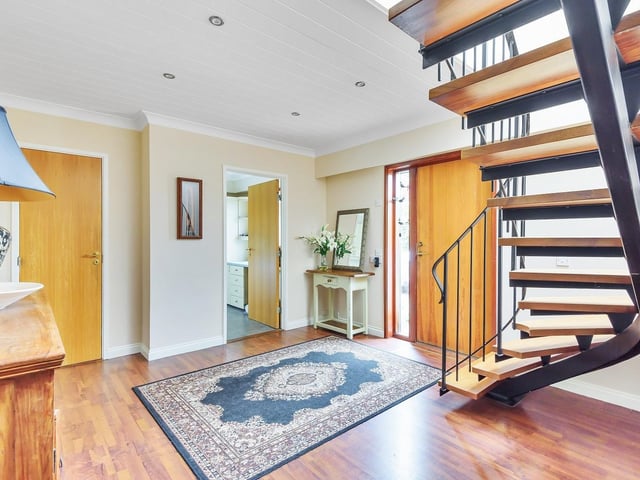 An open feature staircase rises from the hallway to the first floor of this modernised home.