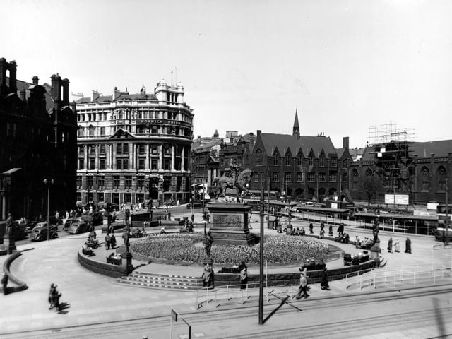 An elevated view of City Square in May 1955, with the circular flower bed and the statue of the Black Prince prominent. Behind is the Norwich Union Building, with Mill Hill Unitarian Chapel on the right, with scaffolding in front. On the left, the General Post Office is just visible.