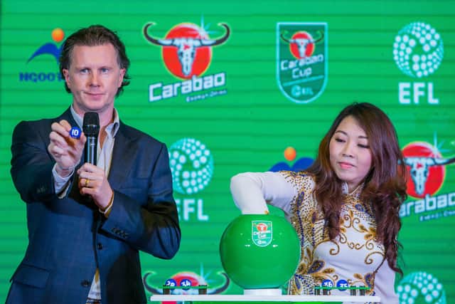 Former Liverpool and Real Madrid star Steve McManaman (L) picks up a number during the Carabao Cup draw for the first round of the English Football League Cup in a ceremony in Ho Chi Minh city on June 15, 2018. - Frank Lampard's Derby County will take on Oldham Athletic away in the first round of the English League Cup, organisers said in Vietnam on June 15, in a key first knockout competition for the former England midfielder. (Photo by Thanh NGUYEN / AFP)