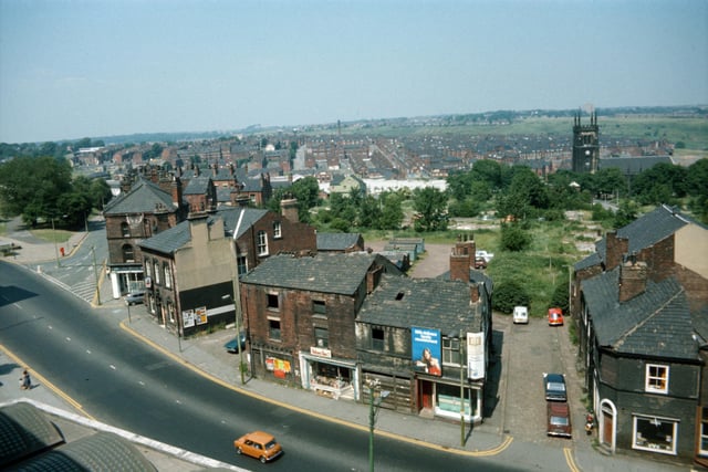 Woodhouse taken from Leeds University Engineering Department in Jun e 1975. Woodhouse Lane runs across in the foreground, with Spenceley Street on the right and Raglan Road leading off on the left. Volume One bookshop is seen in the centre in part of a block of derelict buildings due to be demolished. To the left of this is the Pack Horse public house. St. Mark's Church is seen in the background on the right while on the far left is the corner of Woodhouse Moor.