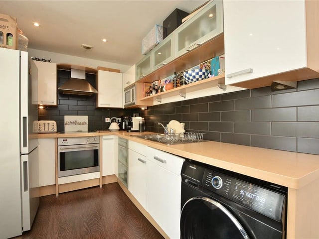 The modern breakfast kitchen has a range of wall and base units, plus light wooden surfaces.
