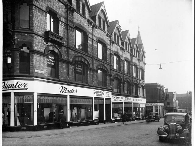 Albion Street, looking south to the Headrow, junction with Woodhouse Lane in September 1935. Number 134, Miss Rhonda Pollard, gowns with window display. Also at this number occuping higher floors at number 132 are Tom Dolby rent and debt collector, Taylors signs, Atlas Advertising Ltd. Ralph Saffman solicitor, Blackburn and Broader business agents. Number 130, Alice Timms Apartment Agency, number 128 Cyril Taylor Motor Tyres. Number 126, on the corner of St Ann Street, Rex Holliday artists supplies. Number 120/122 Premises of Spencer Blackburn Standard Garage, with electrical sign