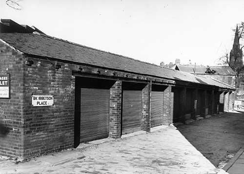 A row of garages on Back Ibbetson Place which were available to rent through Arthur Hainsworth and Co estate agents. The spire just visible on the right belongs to Trininty Congregational Church on Woodhouse Lane. Pictured in March 1966.