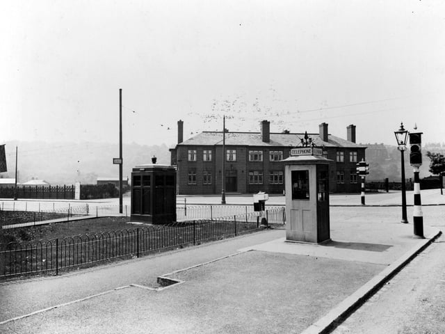 The junction of Meanwood Road and Stainbeck Road in June 1936. On the left, Buslingthorpe Rugby league ground is behind fence with Woodhouse Ridge in the background. Then the Meanwood Hotel, public house, landlord William Cardis. The road to the right of the Meanwood is Grove Lane, Stainbeck Road is in the bottom right corner. Street furniture includes a police box on the left, public telephone box, traffic lights and gas lamp.