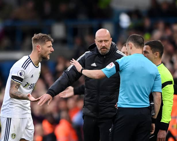 LEEDS, ENGLAND - OCTOBER 02: Liam Cooper of Leeds United protests to Match Referee Stuart Attwell as team mate Luis Sinisterra (not pictured) is shown a red card during the Premier League match between Leeds United and Aston Villa at Elland Road on October 02, 2022 in Leeds, England. (Photo by Stu Forster/Getty Images)