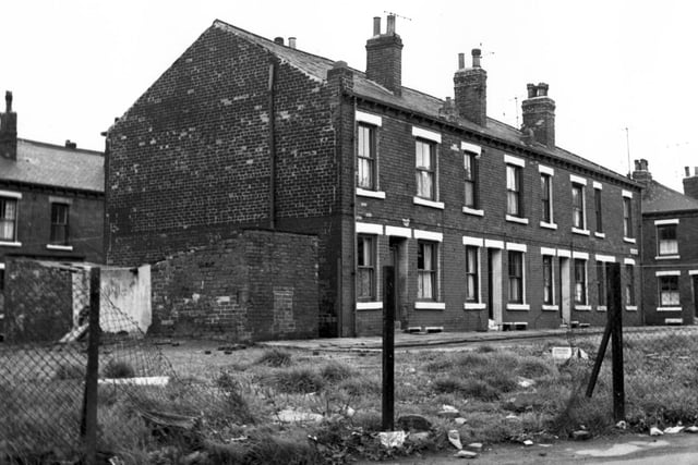 A view looking across from Woodhouse Street to Oakfield Street. On the left Ashfield Street is visible then yards for outside toilets and dustbins. Next Oakfield Street, numbers 1-7 with Oxford Road dividing the street down the middle. The continuation is on the right edge. Pictured in August 1967.