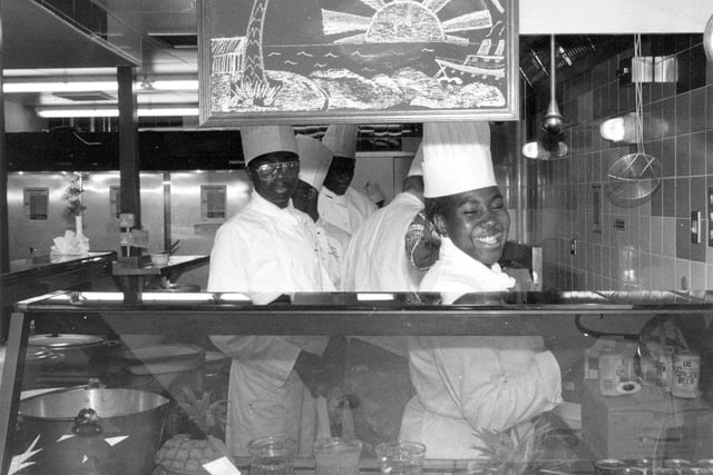 Staff behind the counter of Dr. B's Caribbean restaurant, set up by Doctor Barnado's, the young people's charity. The restaurant was run with funding from Task Force, the Home Office and Leeds City Council. The 36 seater venue provided young people with City and Guilds, Caterbase Hotel and Catering Training Board qualifications over two years, and they were paid YTS training allowances. The restaurant proved very popular for its traditional dishes of Caribbean chicken, steamed fish with cornmeal, stuffed cheese aubergine, served with gunga peas and rice, leaks, plantain and roast potatoes. Pictured in December 1989.