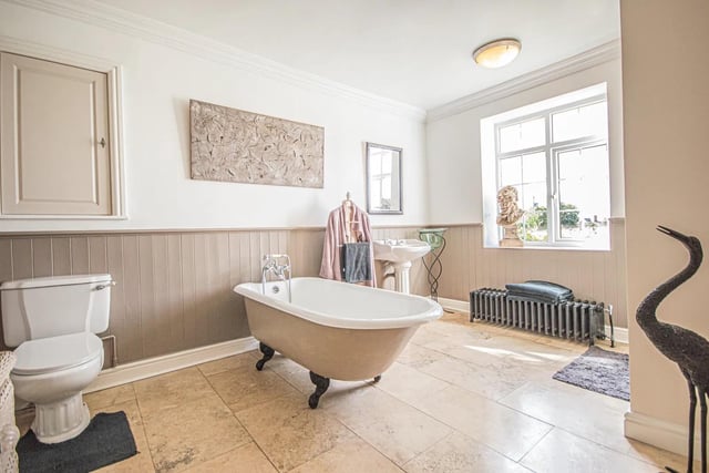 A free standing bath features within this spacious facility.