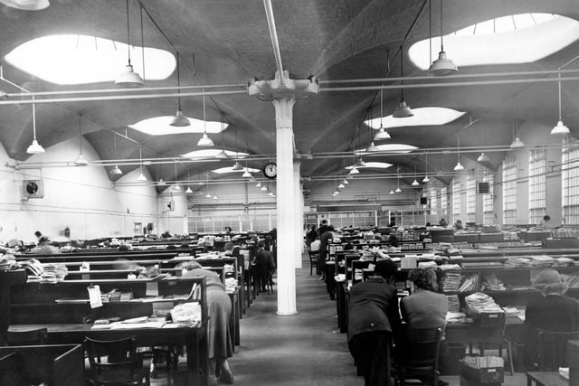 Inside the offices at Marshall's flax spinning mills on west side of Marshall Street. Shelves of files and employees working. Pictured in August 1956.