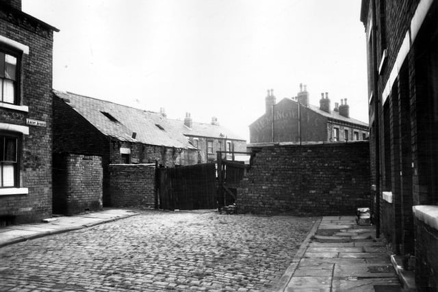 The entrance to a yard at the end of Ascot Avenue, a street of back-to-back terraced houses on the left and through terraced houses on the right. Pictured in July 1963.