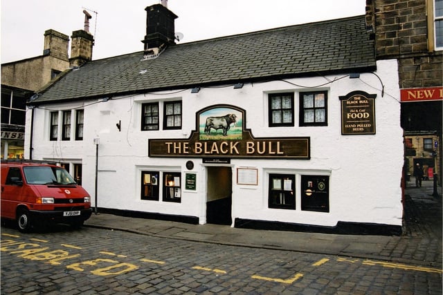 The Black Bull pictured in October 2003. It's thought to be the oldest of Otley's public houses. During alterations in 1971 workmen unearthed a 16th century stone fireplace and a wooden door which, over two hundred years ago, would have given access to the street. There are records that the Inn was visited in 1644 by a party of Cromwell's Ironsides, the night before the battle of Marston Moor, and proceeded to drink it dry. A white painted sign depicting a handsome black bull is in pride of place above the doorway and hand pulled Timothy Taylor's Ales are available within.