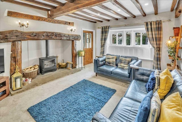 The living room has an exposed beam featured ceiling with carpeted flooring, modern upright gas fired central heating radiator.